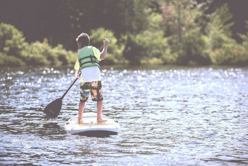 foto di una bambino che va con il paddleboard sul lago