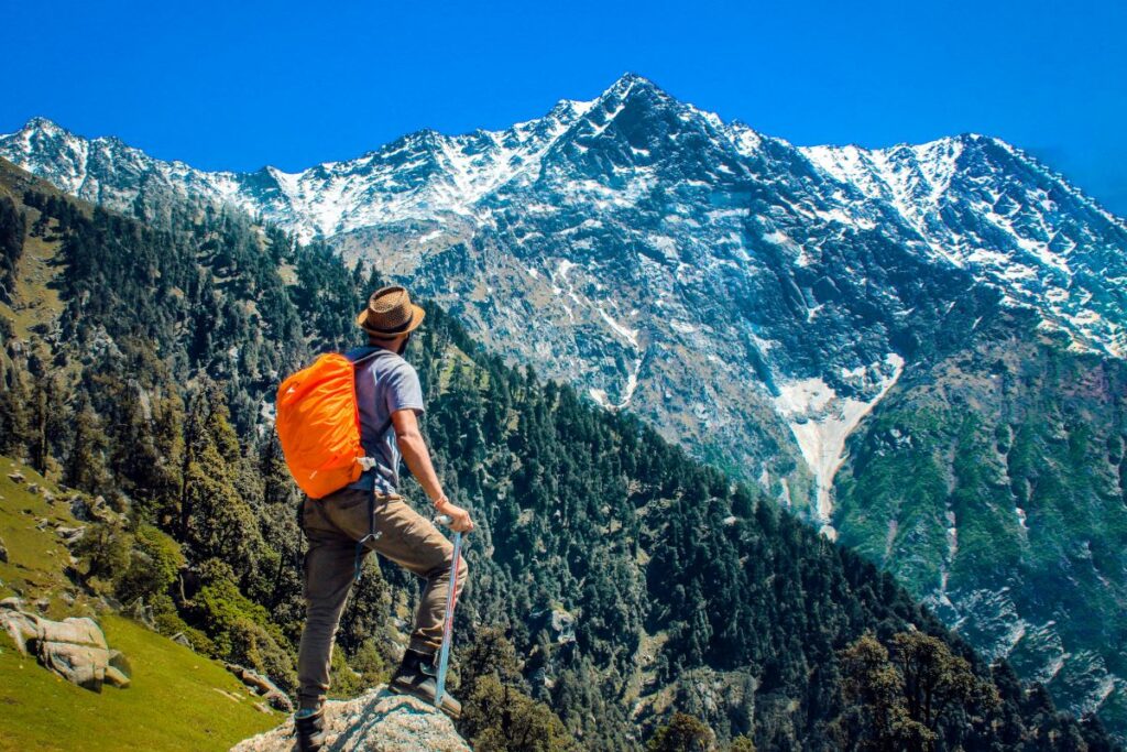 una persona che fa trekking in montagna con zaino arancione