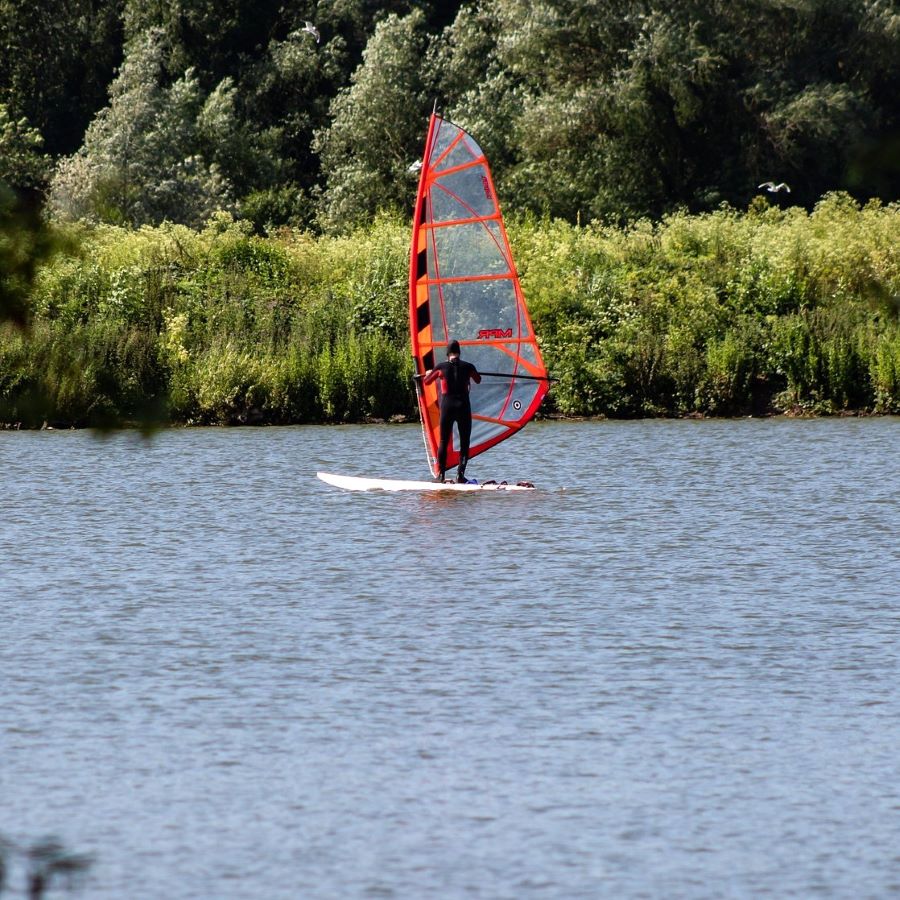 una foto di una persona che fa il windsurf al lago